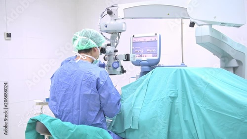Surgeon operating lasik machine. Young white male surgeon operating lasik machine on a senior patient. Advance eye surgery concept. Sliding dolly shot.