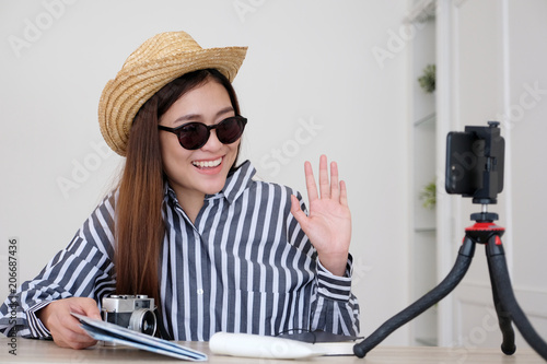 Portrait of young asian woman travel blogger holding map while recording video, live streaming, on social media,  blogger and vlogger concept