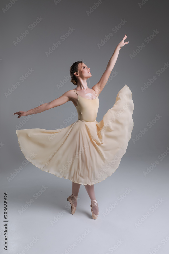 Obraz premium Błogosławieństwo tancerza! Pełnometrażowy obraz młodej wdzięcznej uroczej uśmiechniętej dziewczyny tańczącej w nowoczesnym studiu baletowym.