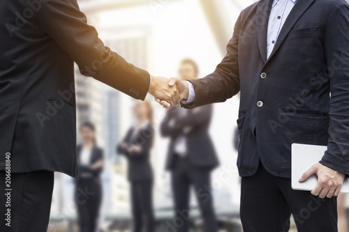 Successful negotiating business concept, Businessmen shaking hands after finishing meeting or setting goals and planning way to success in front of team work