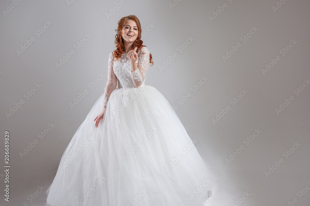 Lovely young woman bride in lavish wedding dress. Light background. Lovely young woman bride in lavish wedding dress. Light background.