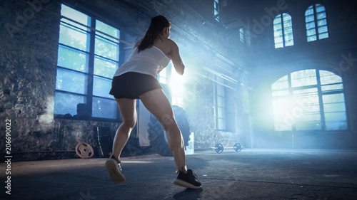 Fit Athletic Woman Does Footwork Running Drill in a Deserted Factory Remodeled into Gym. Cross Fitness Exercise/ Workout Aimed at Strengthening Legs, Enhancing Her Agility and Speed. photo