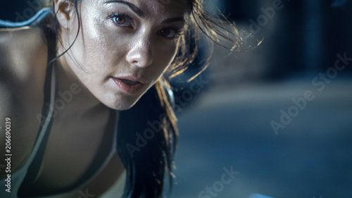 Close-up Shot of a Beautiful Athletic Woman Looks into Camera. She's Tired after Intensive Cross Fitness Exercise. photo