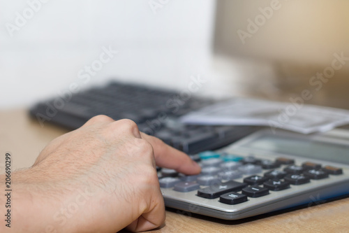 A businessman calculate money by calculator with banknotes on work