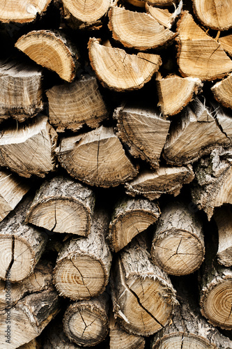 Natural wooden background - closeup of chopped firewood. Firewood stacked and prepared for winter Pile of wood logs.