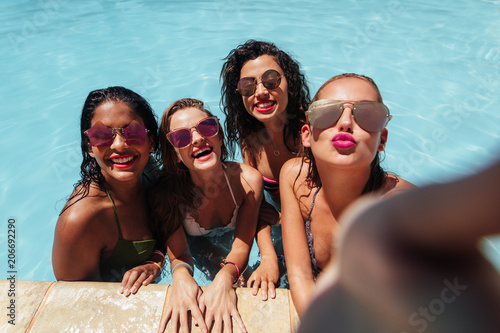 Girls posing for group selfie in pool © Jacob Lund