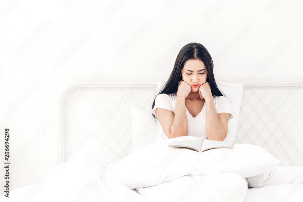 Woman reading book on bed in the morning Woman reading book on bed in the morning
