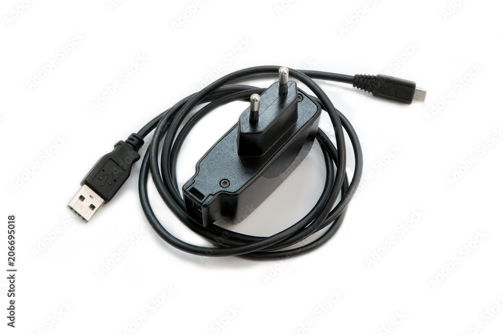 Black power adapter with USB cable for smartphones on a white background. Black power adapter with USB cable for smartphones on a white background.