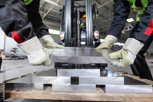 Workers taking aluminium billet photo