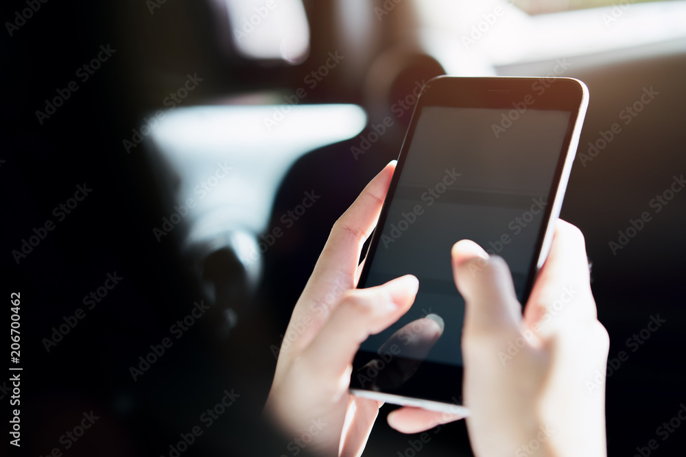 women hoding smartphone on the car in travel trip. vacation time. women hoding smartphone on the car in travel trip. vacation time.