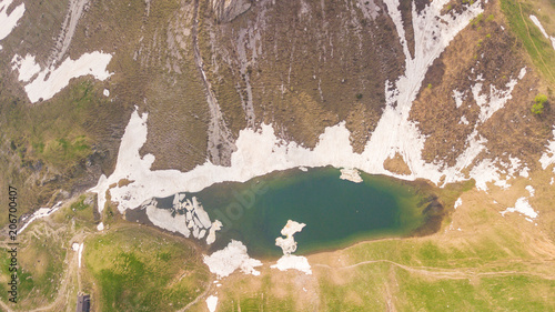 Top and down drone aerial view of the Lake Branchino an Alpine natural lake during spring season. Italian Alps. Italy