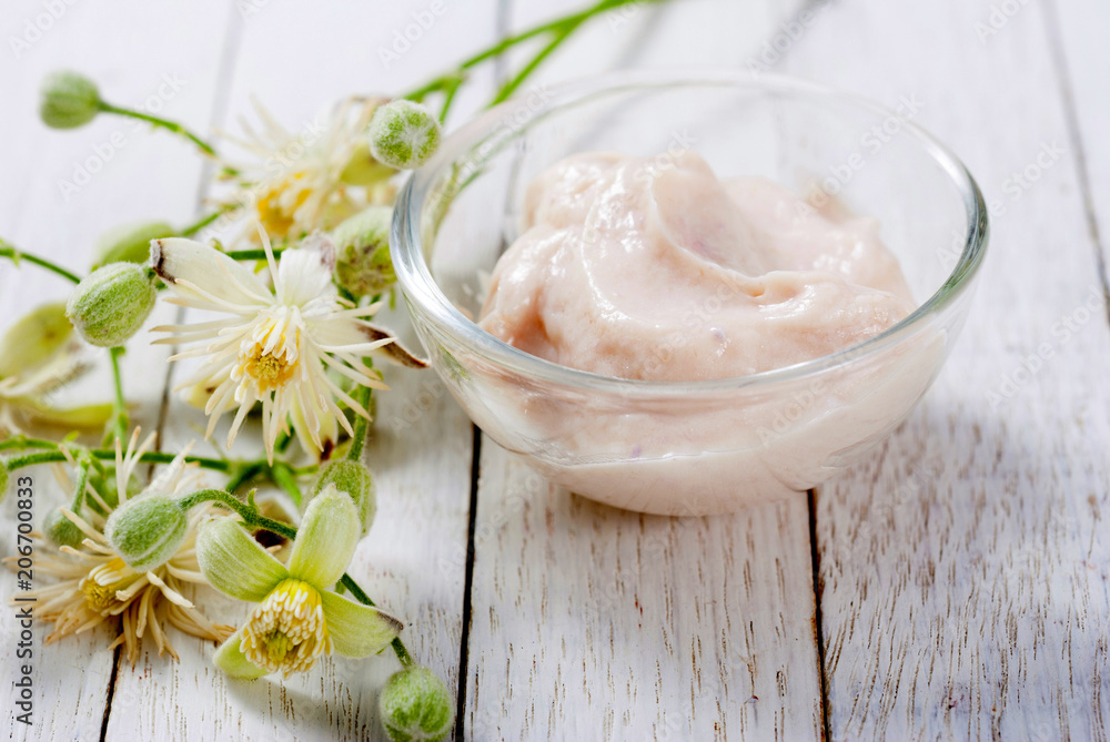 cosmetic cream and white wildflower on bright wood table background cosmetic cream and white wildflower on bright wood table background