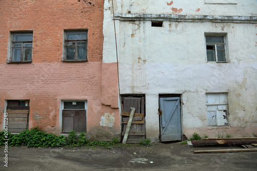 Part of the facade of an abandoned old stone house
