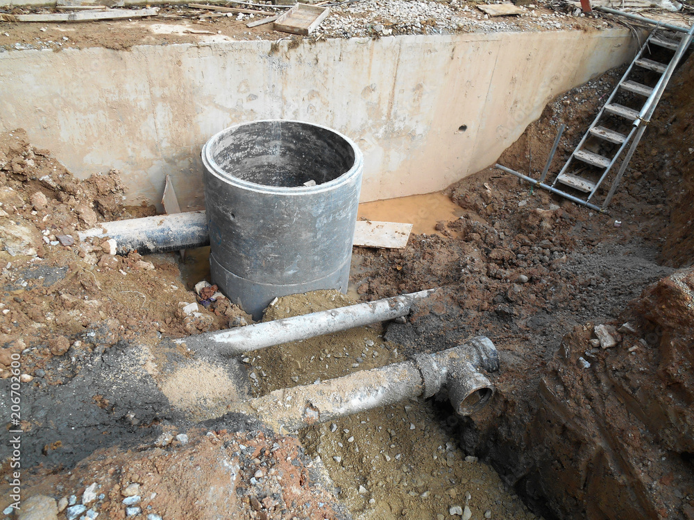 Underground drainage manhole under construction by construction workers ...