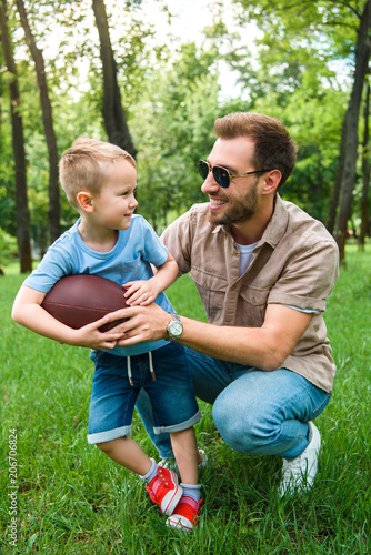 happy father and son with american football ball at park © LIGHTFIELD STUDIOS