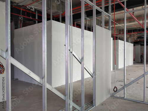 Drywall installation work in progress by construction workers at the construction site. It is the easiest and cheapest way to do partition for interior wall.  photo