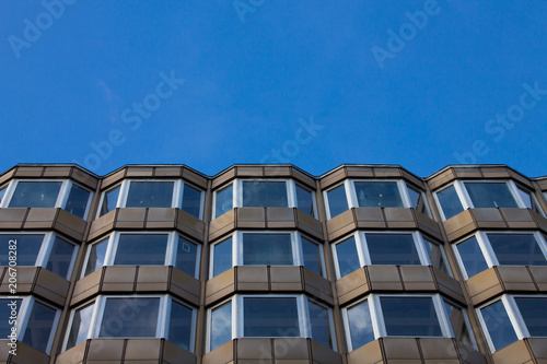 Modern architecture windows see from bottom with sky reflection. Windows pattern. Sky in background.