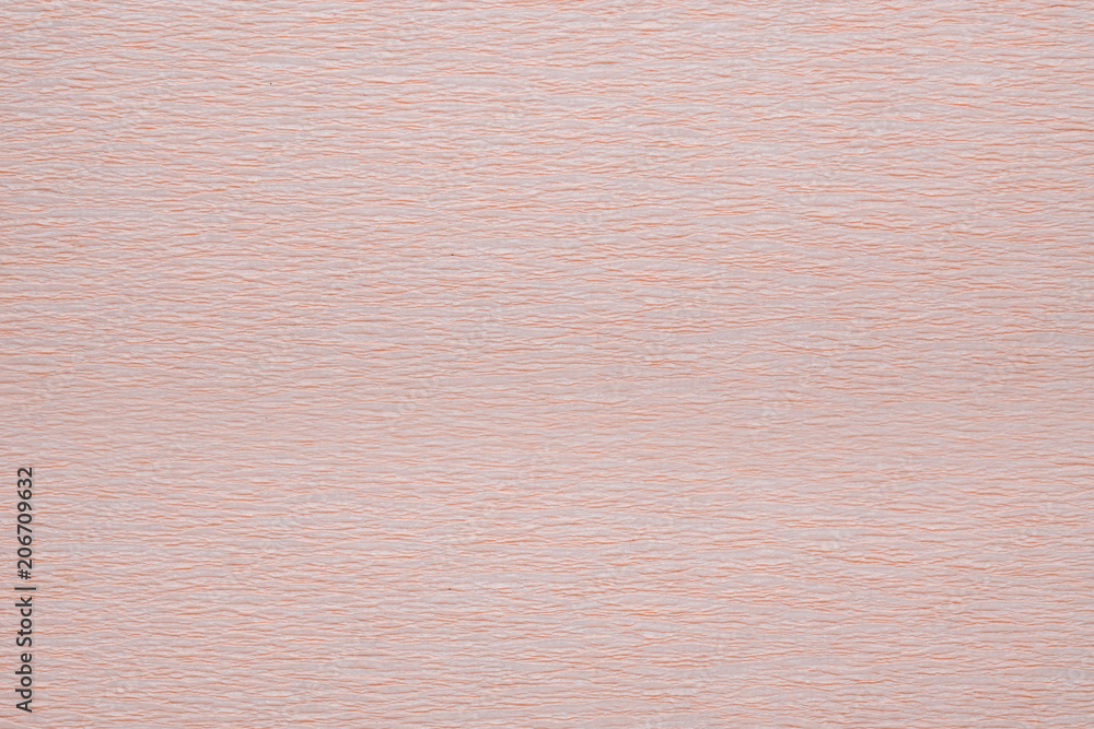Fototapeta premium Texture of corrugated crepe paper of light beige pink color, abstract background
