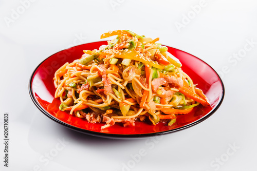 noodles with bacon  pepper and sesame seeds on a red plate on a white background. Traditional Italian pasta. Close