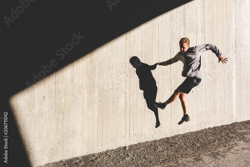 Man doing exercises and jumping on the wall during workout