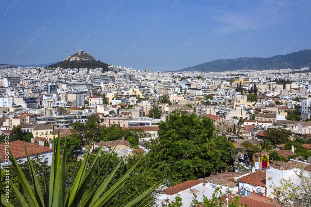 Greece, Athens, Lycabettos: Sunset panorama view of famous popular Mount Lycabettus hill in the city center of the Greek capital with skyline horizon and blue sky in the background.