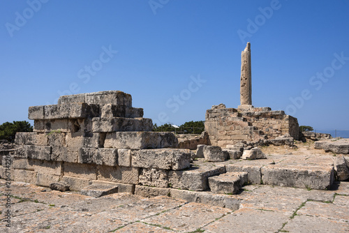 Greece, Aegina: Ruin of famous Temple of Apollo with sun, collumn and blue sky - concept history travel. The patron of Delphi, Apollo was an oracular god, the prophetic deity of the Delphic Oracle.