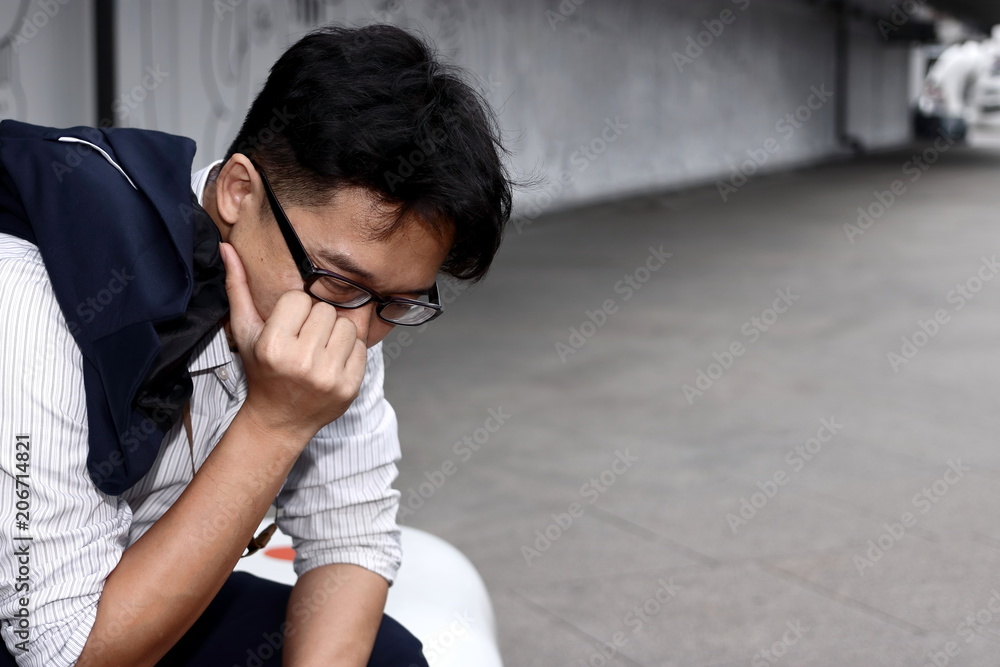 Frustrated stressed young Asian business man suffering from severe trouble Frustrated stressed young Asian business man suffering from severe trouble