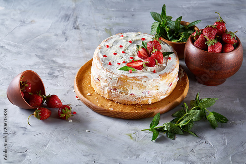 Delicious still life with strawberry tart covered with whipped sour cream, strawberry and mint on white background. photo