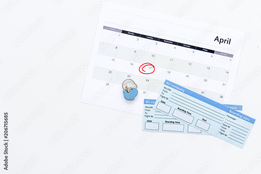 Plan a trip. Buy airplane tickets. Tickets near calendar with date circled on white background top view copy space Plan a trip. Buy airplane tickets. Tickets near calendar with date circled on white background top view copy space