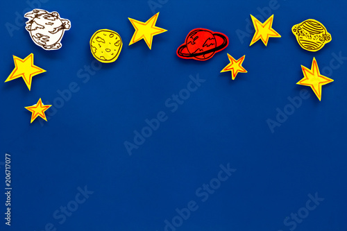Space concept. Drawn stars, planets, asteroids on blue outer space background top view copy space photo