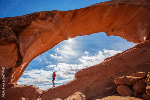 Mother with her baby son stay below Skyline arch in Arches National Park in Utah, USA