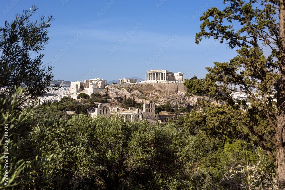 Greece, Athens: Panoramic skyline view of famous Acropolis with Parthenon, Erechtheum, Temple of Athena in the city center of the Greek capital and blue sky in the background - concept travel.