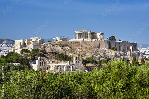 Greece, Athens: Panoramic skyline view of famous Acropolis with Parthenon, Erechtheum, Temple of Athena in the city center of the Greek capital and blue sky in the background - concept architecture.