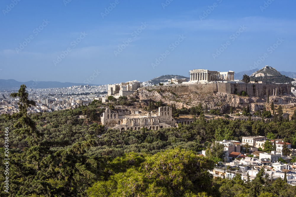 Greece, Athens: Panoramic skyline view of famous Acropolis with Parthenon, Erechtheum, Temple of Athena in the city center of the Greek capital and blue sky in the background - concept travel panorama