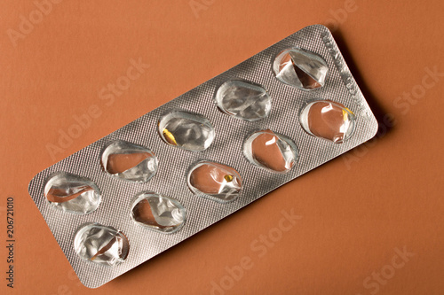 Empty packing from tablets on a brown background. Close up.