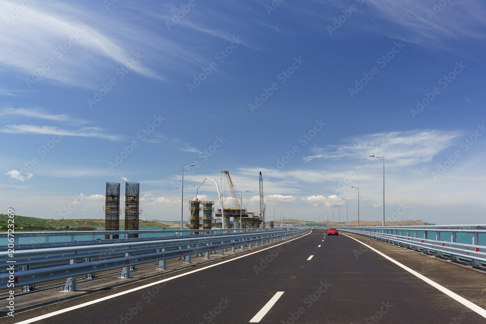 Crimean bridge across the Kerch Strait. On the left is the construction of the railway bridge