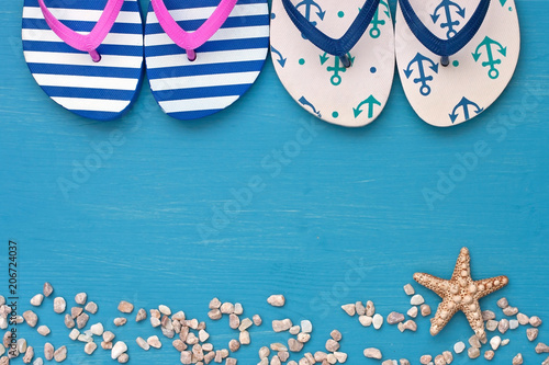 Colorful beach slippers on wooden summer background