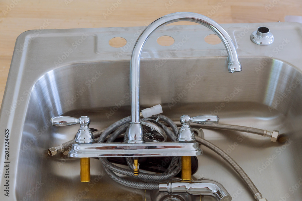 Obraz premium installing a stainless steel kitchen sink.