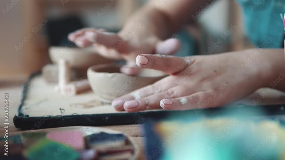 girl is busy with creative work. the process of creating a dish of clay. female hands closeup girl is busy with creative work. the process of creating a dish of clay. female hands closeup