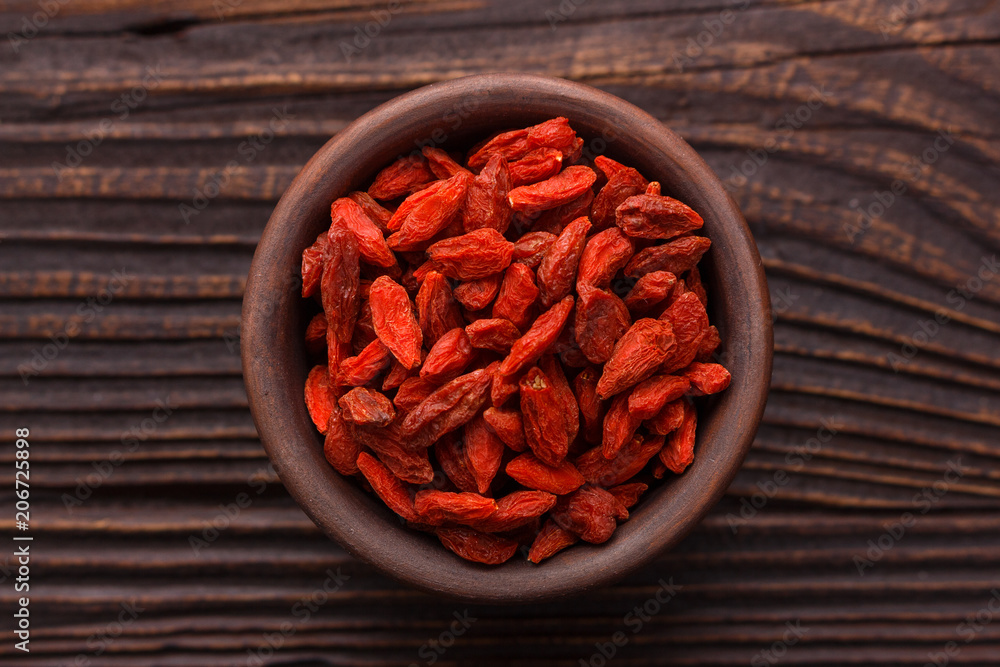 dried goji berries on a wooden rustic background dried goji berries on a wooden rustic background