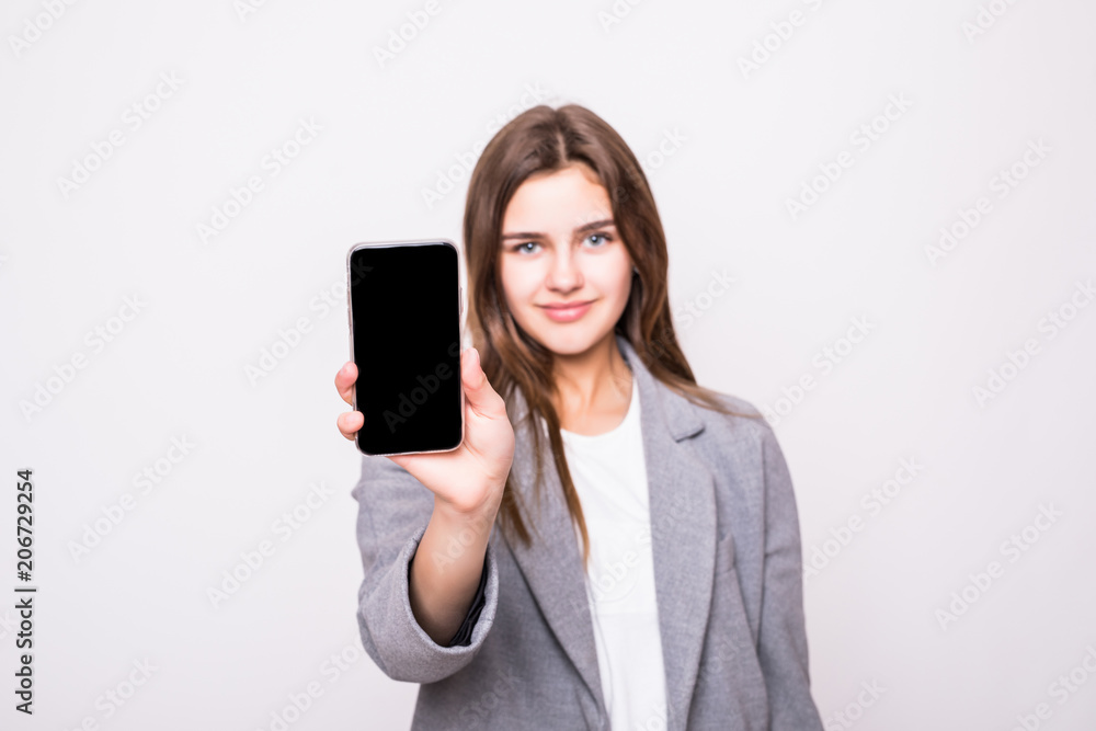 Portrait of a happy casual woman showing blank smartphone screen isolated on a white background Portrait of a happy casual woman showing blank smartphone screen isolated on a white background