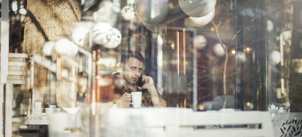 Young attractive man drinking coffee at lunch time