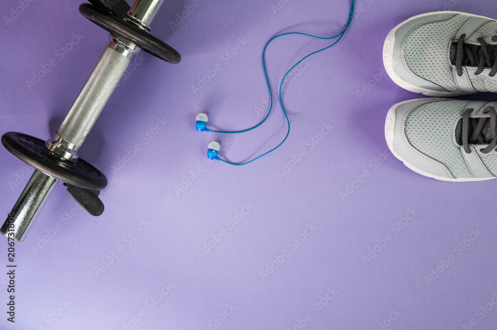 Gray sneakers, dumbbell and blue headphones. Sport and fitness concept. - obrazy, fototapety, plakaty 