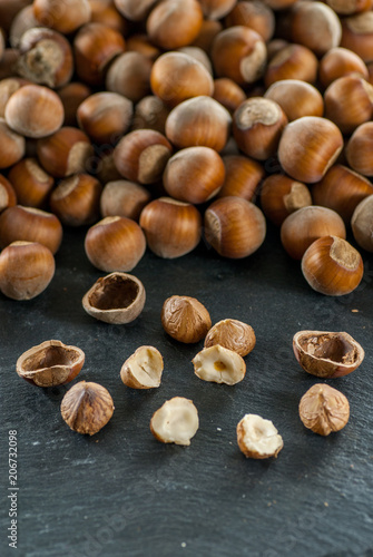 close up photo of a pile of raw hazelnuts on a slate