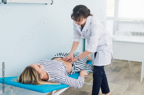 Fotografie Abdominal examination, Doctor is examining the abdomen of patient