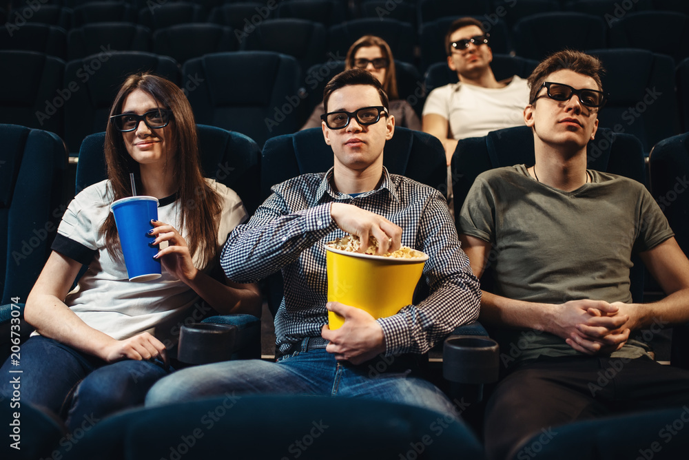 People with popcorn watching movie in cinema People with popcorn watching movie in cinema