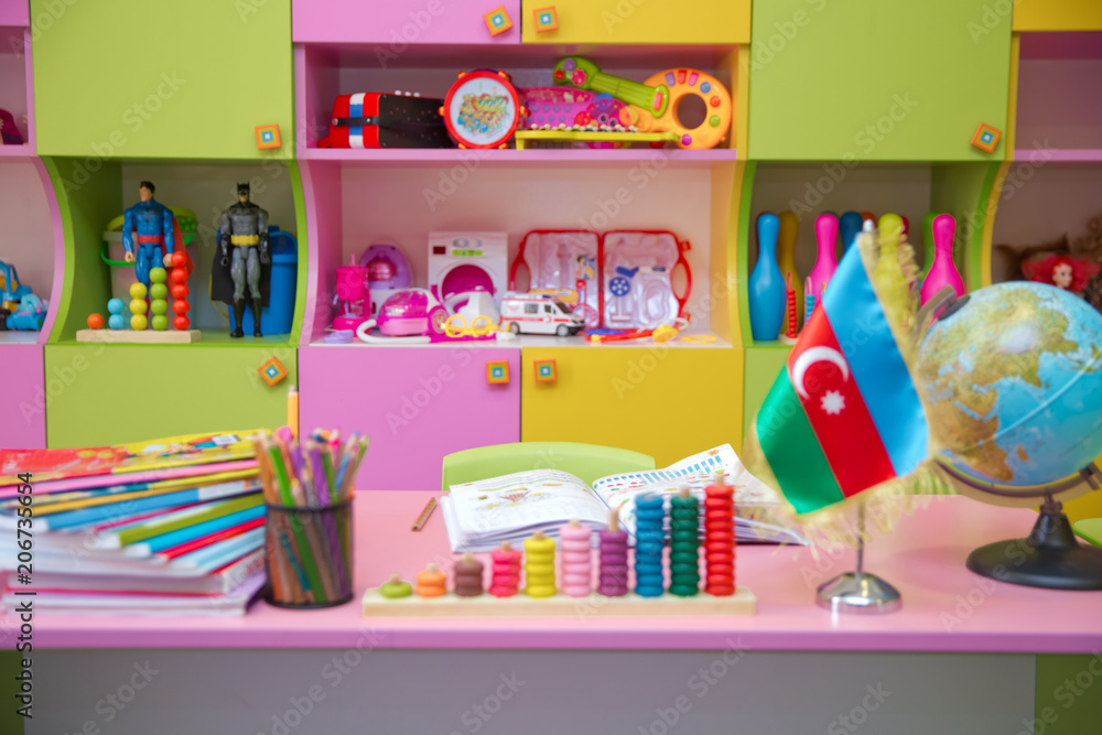 Flag of Azerbaijan for a small table . Kindergarten background . Baku , Azerbaijan . Blurred view of empty playroom Flag of Azerbaijan for a small table . Kindergarten background . Baku , Azerbaijan . Blurred view of empty playroom
