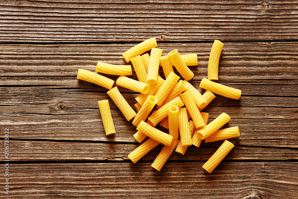 Yellow italian pasta on a wood rustic background