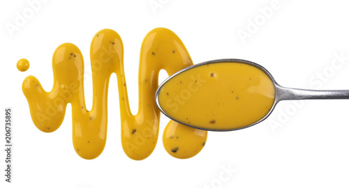 Honey mustard sauce. Splashes and spilled salad dressing with spoon isolated on white background. Top view