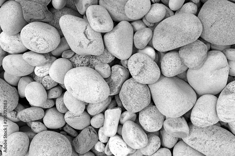 Naklejka Zbliżenie skał, kamyków i głazów na kamienistej plaży, które zostały wygładzone przez falowe działanie wody